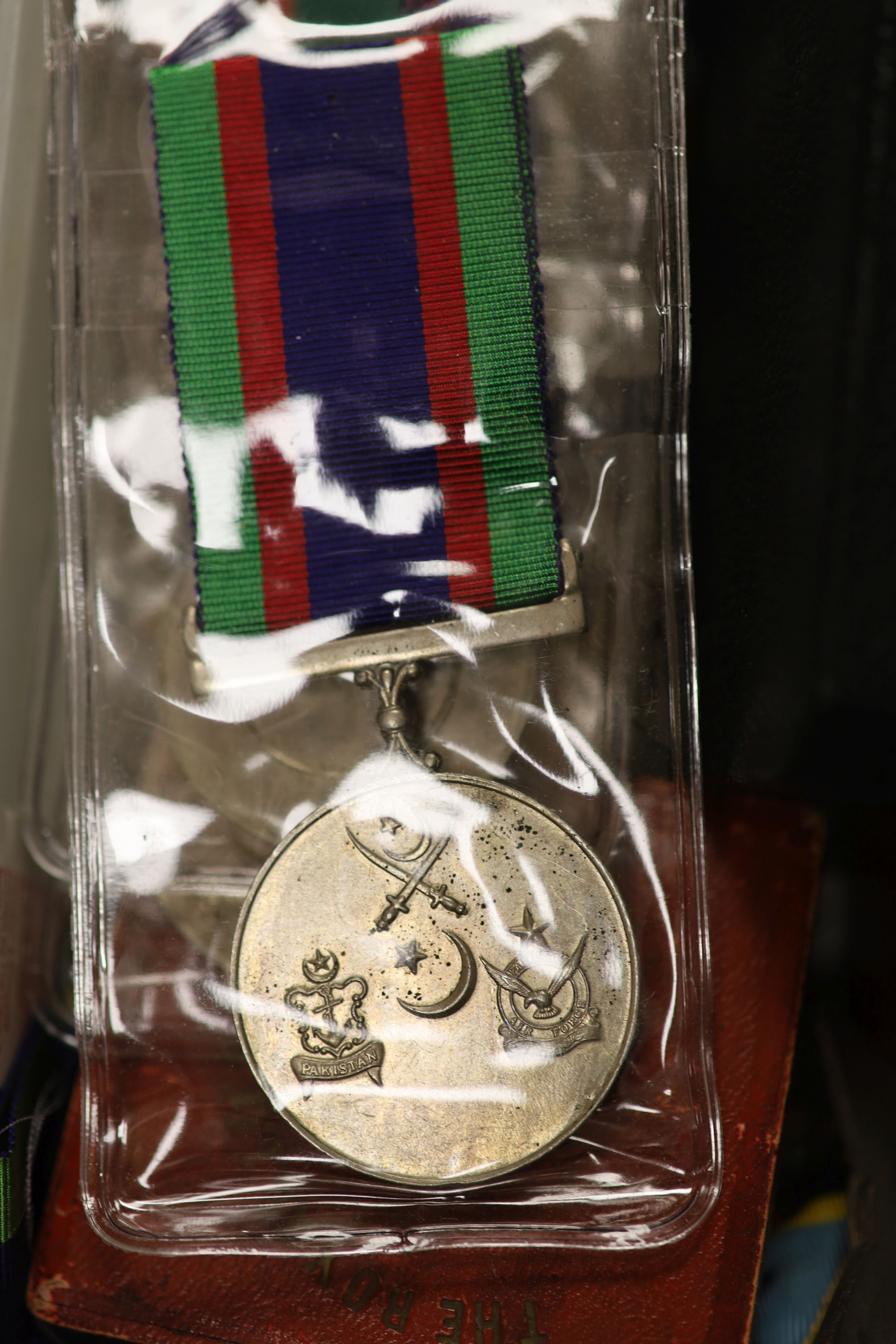 A group of British military cap badges and buttons, various commemorative medals and Pakistan General Service Medals